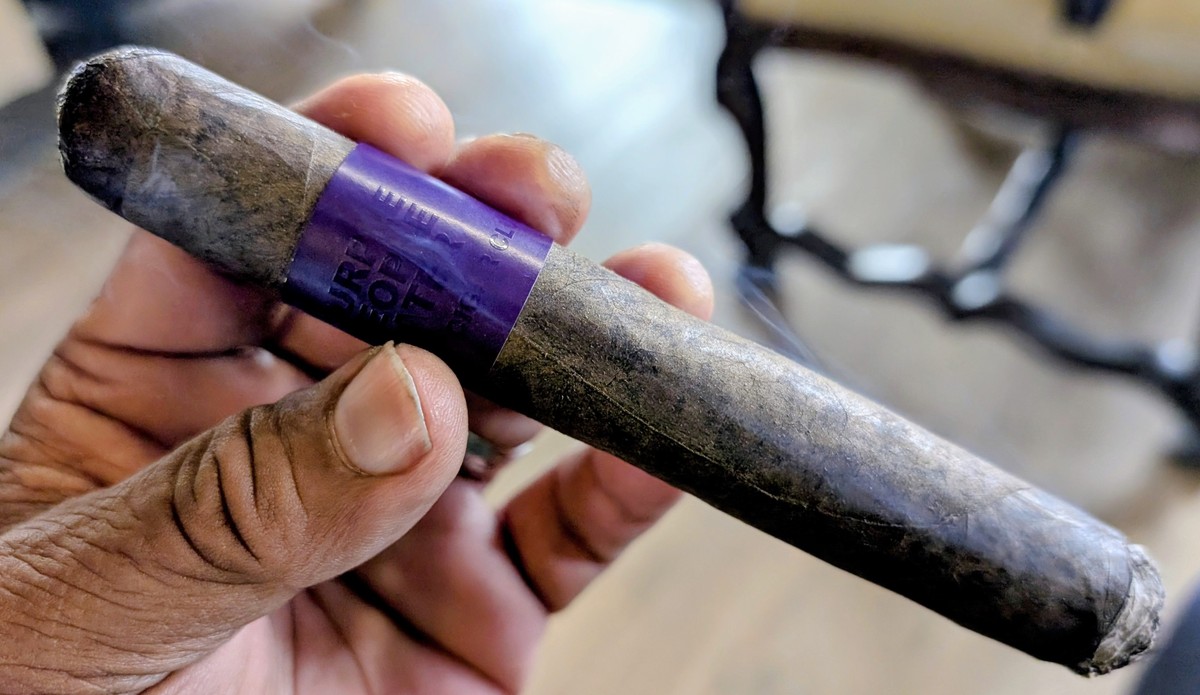 Privada Cigar Club Purple People Eater cigar burning with white ash